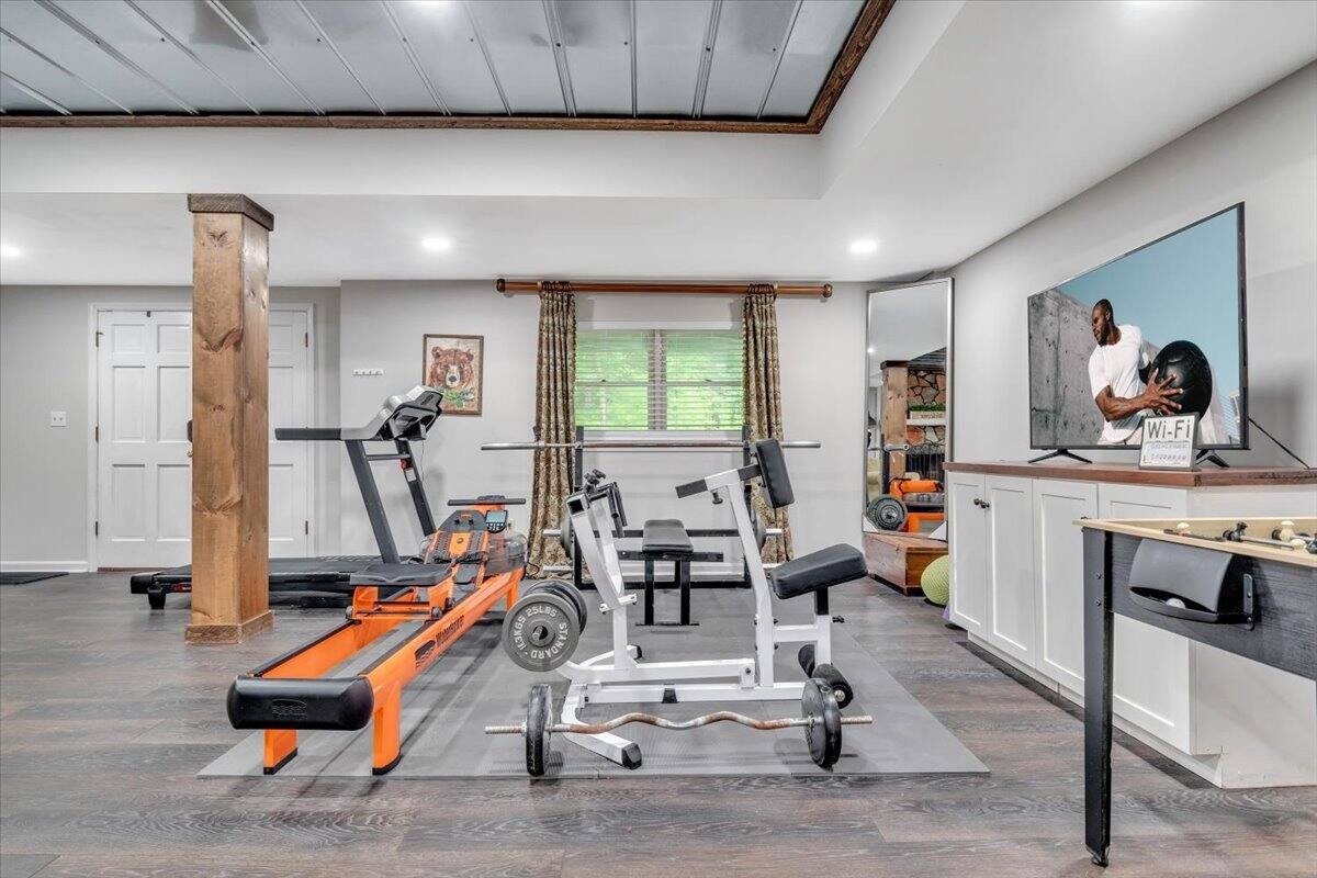 Spacious fitness and recreation room with television and game table